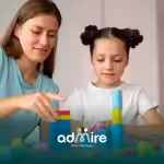 Female therapist guiding an autistic girl during therapy session, building colorful stacking blocks to support speech.