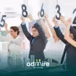 Therapist team holding up numbered score cards during a meeting, rating a presentation in a conference room.