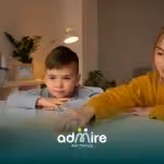 Three autistic kids playing a card game together at a table, showing communication, attention, and social interaction skills.