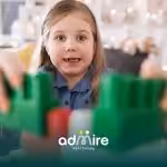 Autistic girl building with colorful blocks indoors, symbolizing growth, learning progress, and developmental changes