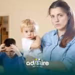 Parent holds autistic toddler as another adult looks stressed, reflecting family concerns and autism misconceptions.