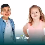 Autistic young boy & girl smiling confidently against a white background, representing gender differences in autism diagnosis