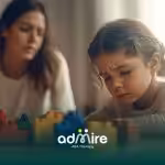 Autistic child playing with colorful blocks while a therapist observes, supporting problem-solving and structured play.