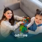 n autistic child playing with a toy while an adult observes, representing sensory behaviors and developmental differences.