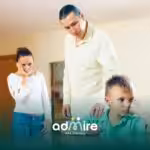 Therapists standing behind a sad child seated at a table, illustrating family concern and emotional challenges.