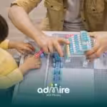 Therapist guiding autistic girl with colorful building blocks on a table, supporting fine motor skills and hands-on learning