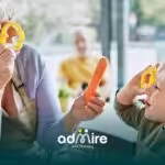 Therapist and autistic boy play with vegetable cutters in a kitchen, representing learning and developmental interaction.