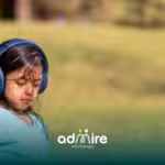 Autistic girl wearing noise-canceling headphones outdoors, managing sensory sensitivity and reducing environmental sounds