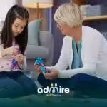 Therapist works with autistic child & parent in clinic, discussing treatment plan and supporting autism care & ABA progress