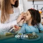 Therapist offering a banana slice to an autistic girl during breakfast, supporting healthy eating habits and food acceptance.