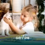 Autistic girl gently interacting with her pet cat at a table, supporting emotional connection and social development.
