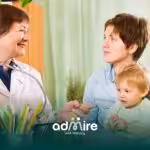 Therapist speaks with a parent & autistic child during a consultation, discussing developmental milestones