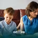 Parents & autistic boy practice learning activities together at home using books and worksheets after ABA therapy session