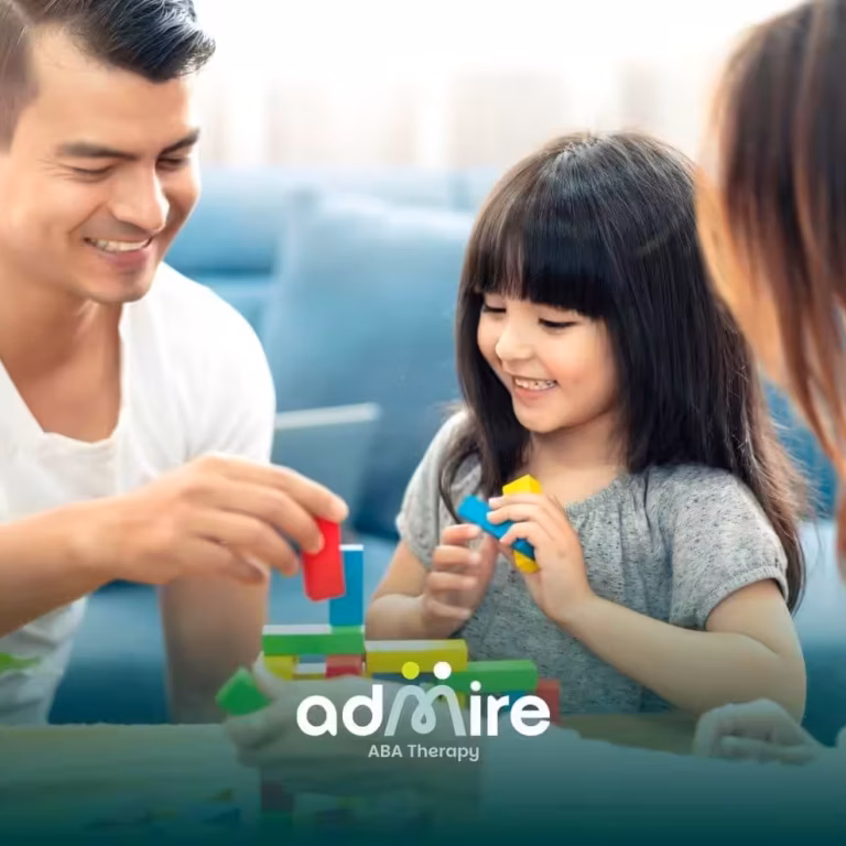 Therapists & autistic girl building colorful blocks together during a fun activity that encourages learning & play.