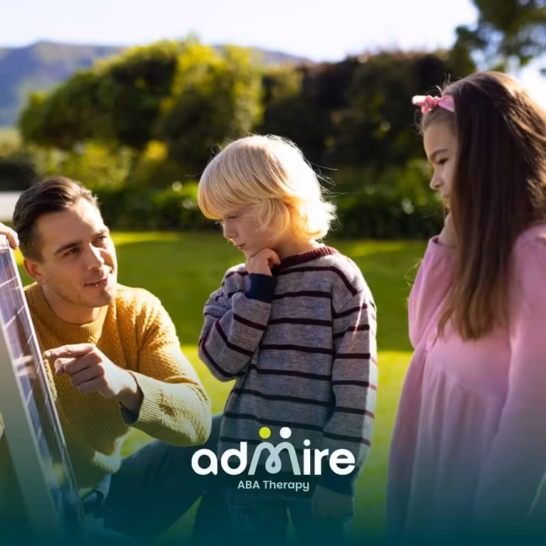 Therapist guides two autistic kids at a sunny park activity board, fostering learning and family‑friendly engagement.