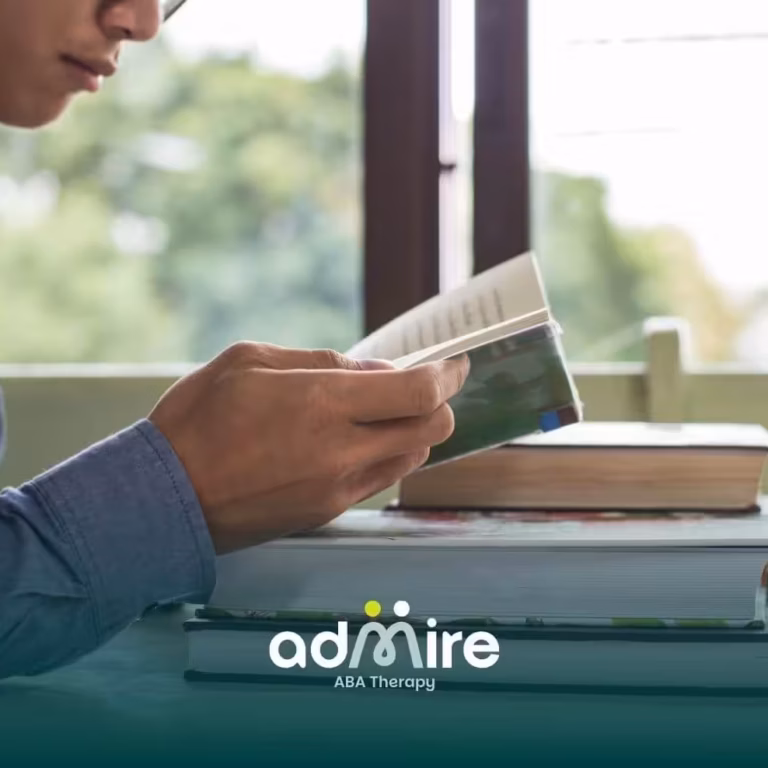 Therapist reads at a desk with stacked books, highlighting concentration, learning, and independent study skills.