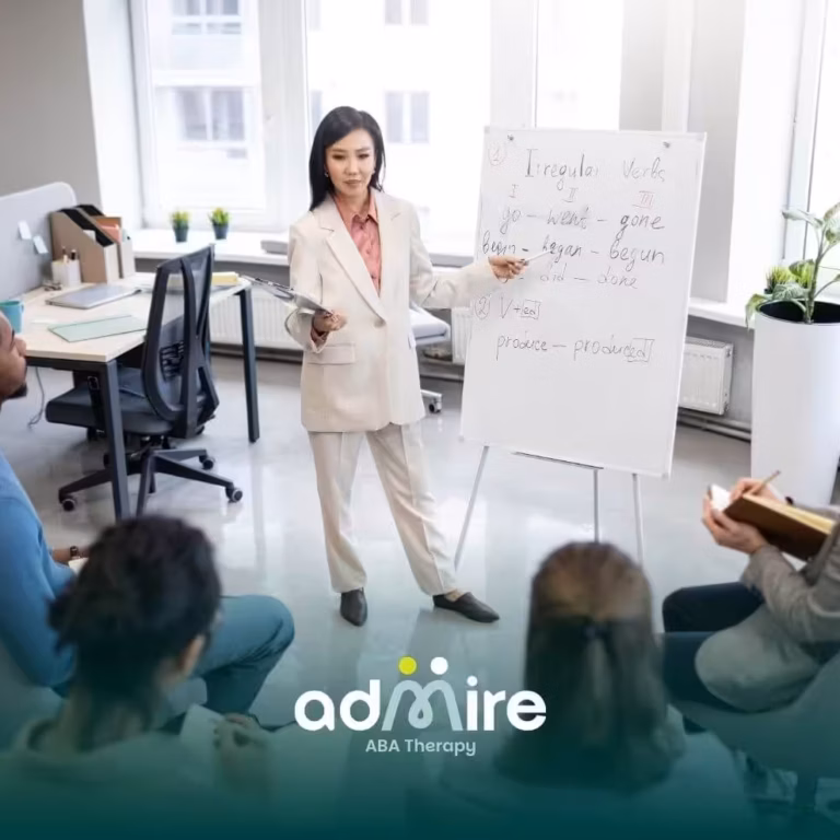  A therapist leading a small group training session with a whiteboard, representing hands-on RBT training & skill development.