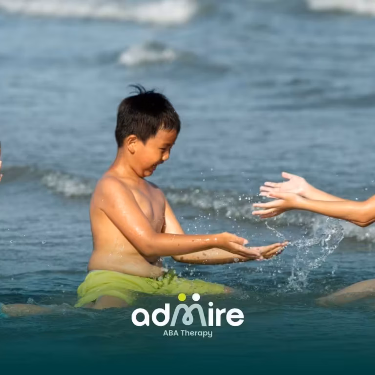 Three autistic children laugh and splash water together while playing in shallow ocean waves on a sunny day at the beach.