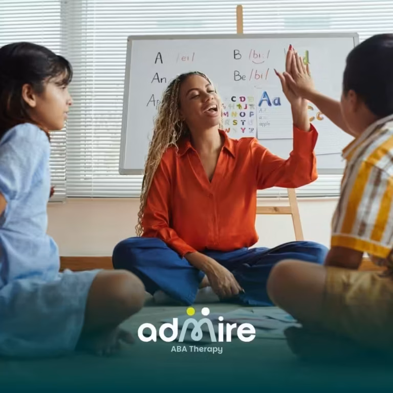 Therapist gives autistic kids a high-five during an interactive alphabet lesson while another child watches