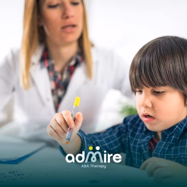 Autistic boy focusing on drawing shapes with a marker while a therapist or teacher guides him during a learning session.
