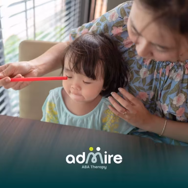 Therapist gently guiding autistic girl during structured activity at table, supporting focus and communication development